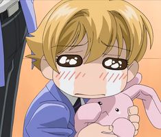 an anime character holding a stuffed animal in his right hand and looking at the camera