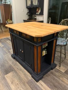 a kitchen island made out of wood and black with an open shelf on the top