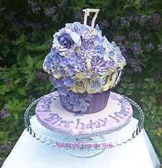 a purple and white cake with flowers on top