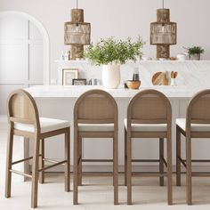 a table with four chairs around it and some plants on the counter in front of it