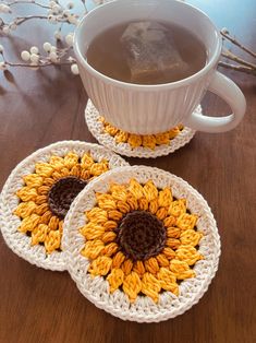 two crocheted sunflower coasters next to a cup of coffee