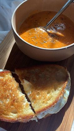 a bowl of soup next to a piece of bread