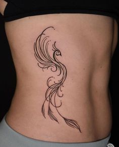 a woman's stomach with a black and white tattoo design on the side of her body