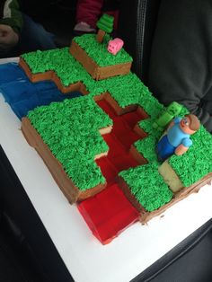 a cake made to look like a train track with green frosting and a man on it