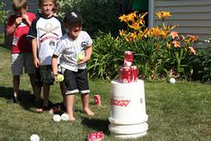 three young boys are playing baseball in the yard with their balls and water bottles on the grass