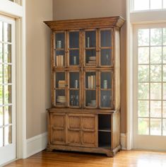 an old wooden bookcase with glass doors in a living room