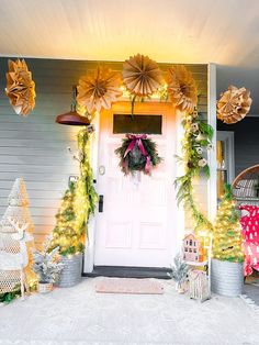 a front porch decorated for christmas with wreaths, lights and decorations on the door