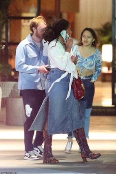 two women and a man are kissing on the street