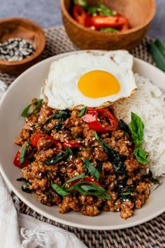 a white plate topped with rice, meat and an egg