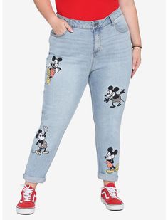 a woman in red shirt and jeans with mickey mouse patches on the side of her pants