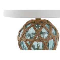 a blue glass ball with rope wrapped around it on a white table lamp shade holder