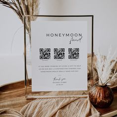 a wooden table topped with a vase filled with dried grass and a sign that says honeymoon spirit