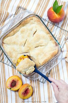 a person is holding a spoon in front of a dish with peaches and a piece of pie