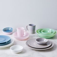 there are many plates and cups on the table