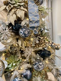 a christmas tree decorated with blue and gold ornaments