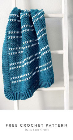 a blue knitted blanket hanging on a ladder with the text free crochet pattern