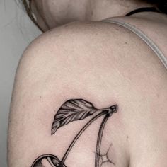 a woman with a tattoo on her shoulder has an apple in the shape of a letter