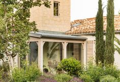 a house with an orange tiled roof surrounded by greenery