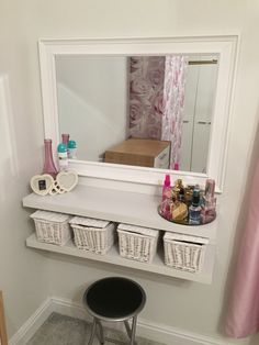 a white shelf with baskets under a mirror