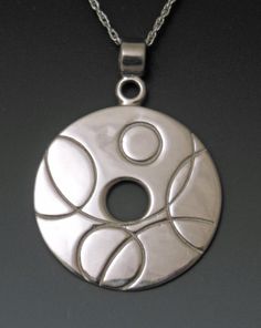 a silver pendant with two circles on it