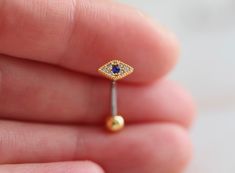 a tiny gold nose ring with an evil eye on the front, and a blue stone in the middle