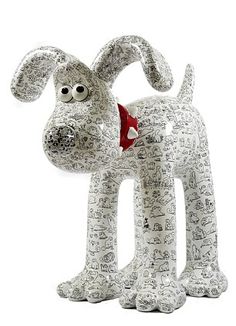 a statue of a dog wearing a red collar and bandanna on its head is shown in front of a white background