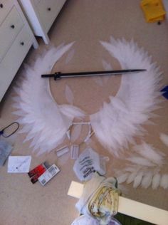 a white feathered object is laying on the floor next to other items and papers