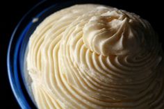 a blue plate topped with white frosting on top of a table