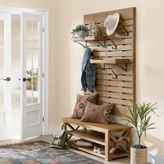 a wooden bench sitting in front of a white door next to a potted plant