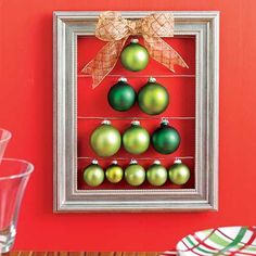 a christmas ornament hanging on a red wall in front of a silver frame