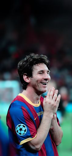 a soccer player is applauding with his hands in the air while smiling and clapping