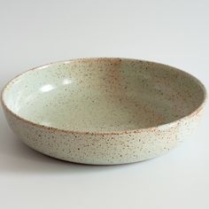 a white bowl with brown speckles on it