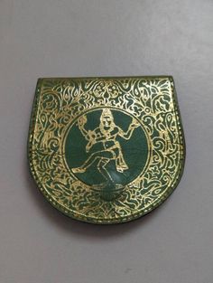 a green and gold plate with a skeleton on it