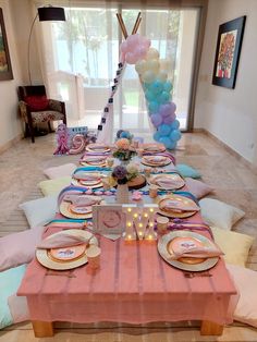 a table set up for a party with balloons and plates