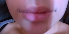 a woman's nose with piercings on it and the bottom part of her lip