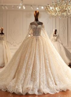 a wedding dress is displayed in front of mannequins and chandeliers