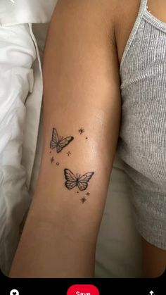 a woman's arm with two butterflies and stars tattoo on the left side of her arm