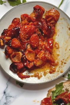 a white plate topped with meat covered in sauce