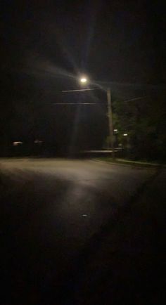 an empty street at night with the light on