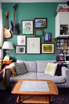 a living room filled with furniture and lots of framed pictures on the wall above it