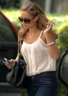 a woman walking down the street while using her cell phone