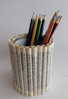 several pencils in a cup made out of old books