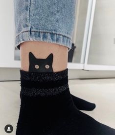 a person with a cat tattoo on their ankle