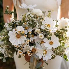 a bride holding a bouquet of white flowers