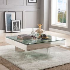 a glass coffee table sitting on top of a rug