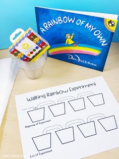 a table with an activity book, cup and pencils on it next to the rainbow of my own