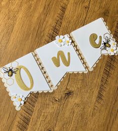 a wooden table topped with paper cut outs and gold foil lettering that spell out the word love