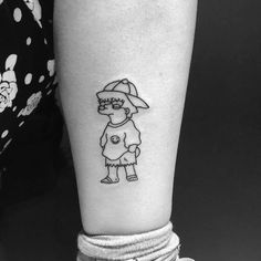 a black and white photo of a person with a cartoon character tattoo on their leg