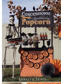 a halloween display with skeleton decorations and an orange fan in front of a white fence