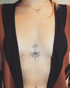 a woman's chest with a small tattoo on her left side and an arrow in the middle